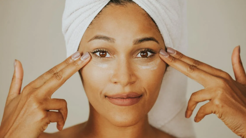 Mulher negra de toalha na cabeça mostrando sua pele após utilizar produto com colágeno biomimético